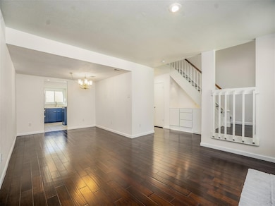 Living area with high ceilings and nice built in drawers and cabinets under the staircase.