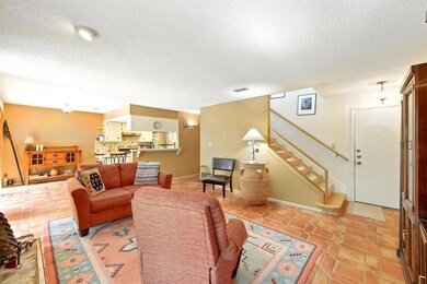 Living room featuring a textured ceiling, stairs,