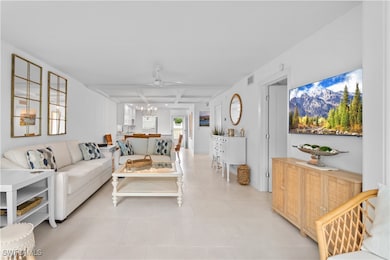 Tiled living room featuring beamed ceiling, coffered ceiling, and ceiling fan