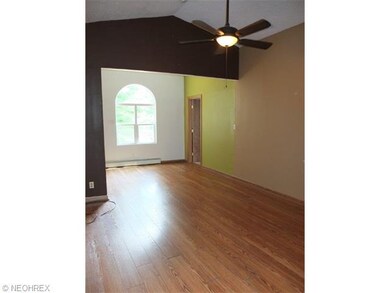 Living room with vaulted ceiling is open to the di