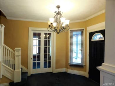 Foyer. Beautiful woodwork and double French doors 