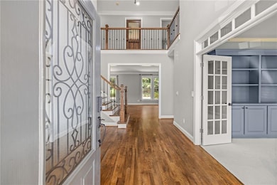 Foyer featuring stairway, dark wood-type flooring, crown molding, and a towering ceiling