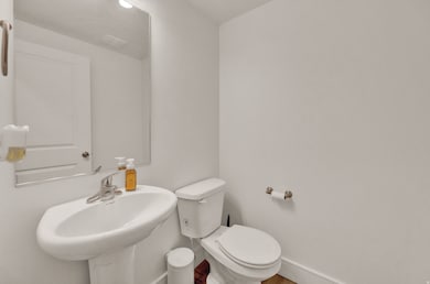 Half bathroom with toilet and baseboards