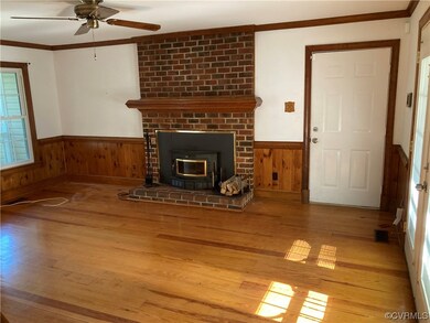 Hardwood floored living room featuring brick wall,