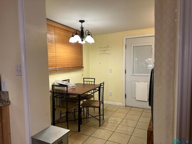 Dining space featuring light tile patterned floors and a chandelier