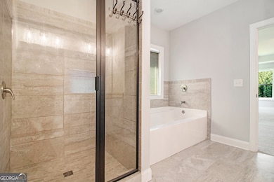 Spa-Like Bathroom complete with a Double Stone Vanity, Soaking Tub, Separate Shower, and an Oversized Walk-In Closet