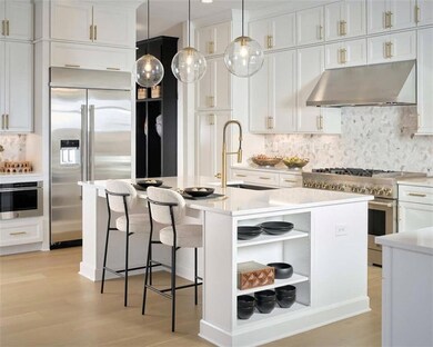 Kitchen featuring a kitchen island with sink, ligh