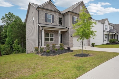 Craftsman-style home with board and batten siding, concrete driveway, an attached garage, brick siding, and a front lawn