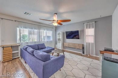 Living area featuring ceiling fan and light wood-style flooring