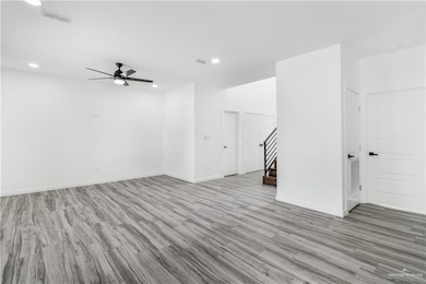 Spare room featuring light wood-style flooring, stairway, a ceiling fan, and recessed lighting