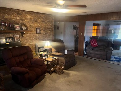 Carpeted living room featuring ceiling fan and a t