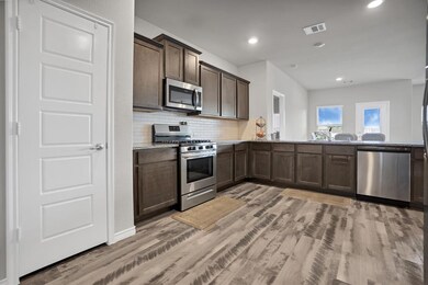 Top of the line stainless steel appliances,  recessed lighting, and room for more than one cook in the kitchen