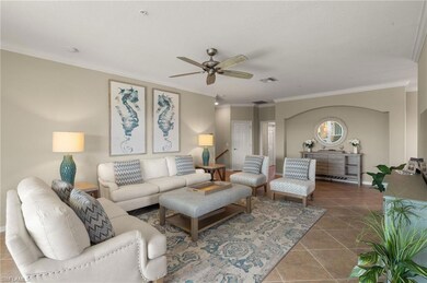 Tiled living room featuring crown molding, ceiling