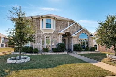 Traditional home with a front lawn and brick siding