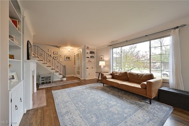 Living room featuring stairs and dark wood-style floors