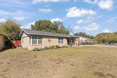 Ranch-style home with a front lawn, brick siding, driveway, and a carport