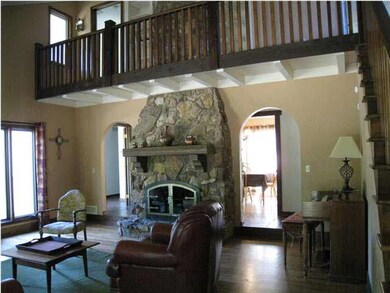 Wonderful living room/stone fireplace with balcony