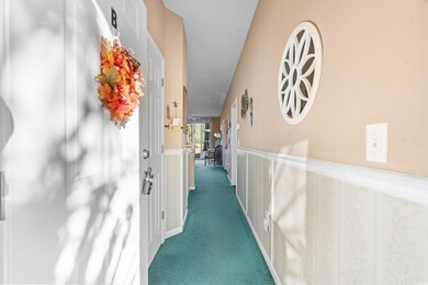 Hallway featuring dark colored carpet