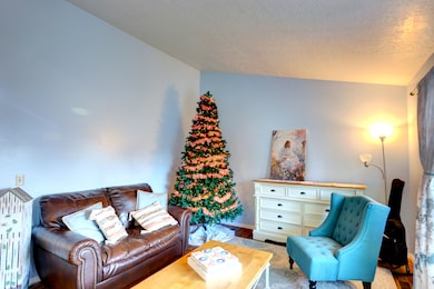 Living area featuring wood finished floors and a textured ceiling