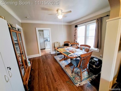 Dining room featuring wood finished floors, crown molding, and ceiling fan