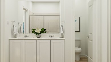 Full bath with a tile shower, double vanity, and wood finished floors