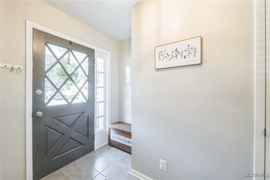 Foyer entrance with light tile patterned flooring