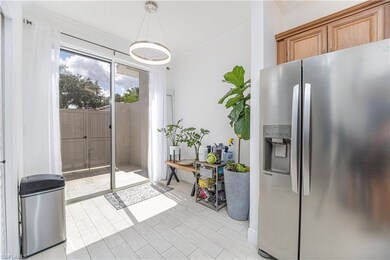 Kitchen with stainless steel refrigerator with ice dispenser, ornamental molding, wood tiled floors, brown cabinets, and decorative light fixtures