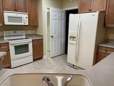 Kitchen with white appliances, light countertops,