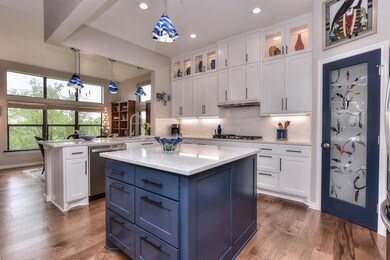 Kitchen featuring a sink, a peninsula, white cabi