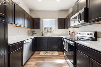 Kitchen with dark brown cabinetry, stainless steel