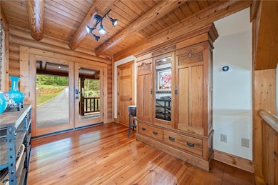 Doorway featuring rustic walls, light wood-style f
