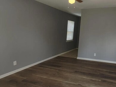 Spare room featuring ceiling fan and dark wood-type flooring