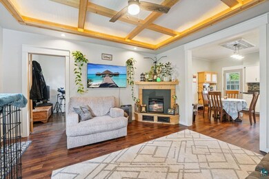Living room featuring coffered ceiling, dark wood finished floors, beam ceiling, a ceiling fan, and recessed lighting