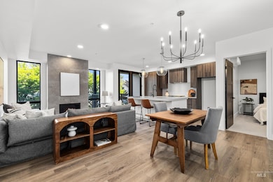 Dining area featuring light wood-type flooring, recessed lighting, a chandelier, and a tile fireplace
