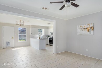 Tiled spare room featuring ceiling fan with notabl