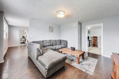 living area featuring a textured ceiling and dark wood-style flooring