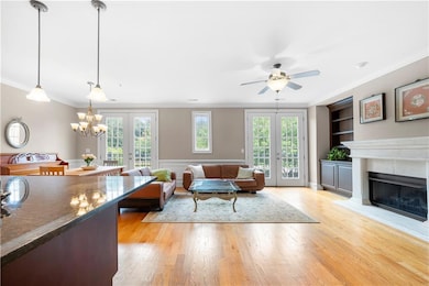 Living room featuring crown molding, a tiled firep