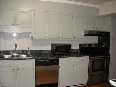 Kitchen with stainless appliances and subway tile backsplash.