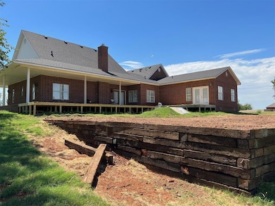 Back of house with a chimney and brick siding