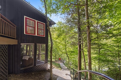 This view shows the screen porch, the stone steps to the driveway and the entrance to one of the community docks on the lake.