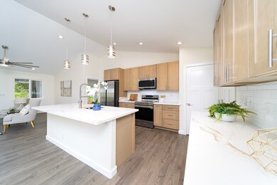Open kitchen with gorgeous wood cabinets and quartz countertops.