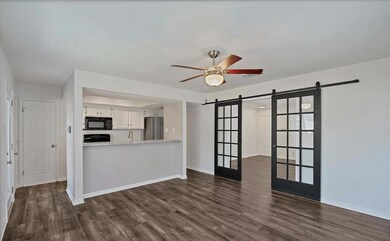 Unfurnished living room with a barn door, dark wo