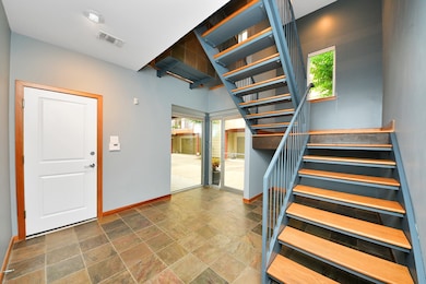 From the foyer, enjoy an inviting view up the staircase, along with clear sightlines to both the front entry and the garage door—creating a seamless and welcoming first impression.