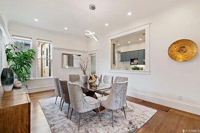 Grand formal dining room with recessed and custom lighting and a large pass through to the chef’s kitchen