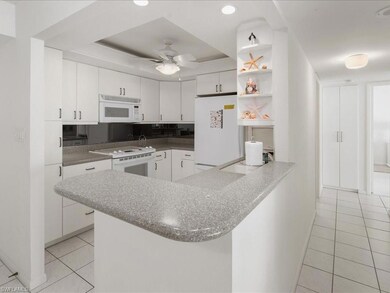 Kitchen featuring ceiling fan, white cabinets, kit