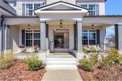 Doorway to property featuring a porch and brick si