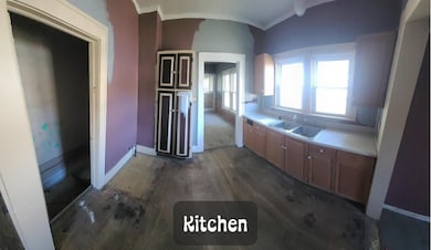 Kitchen featuring light countertops, dark wood finished floors, and ornamental molding