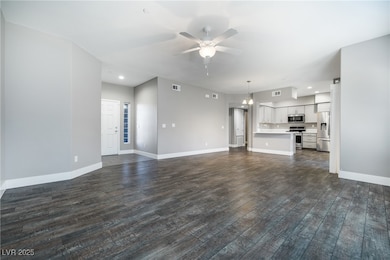 Unfurnished living room with ceiling fan, dark woo