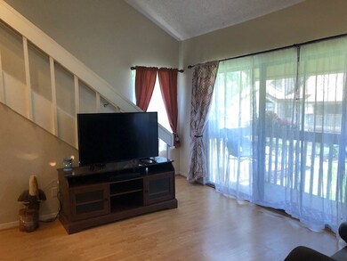 OPEN LIVING ROOM WITH HIGH CEILING AND STAIR LEADI