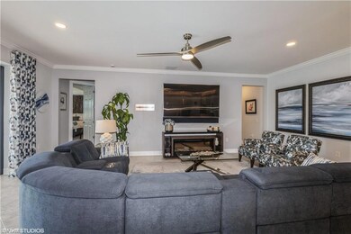 Living room with ceiling fan, ornamental molding, 